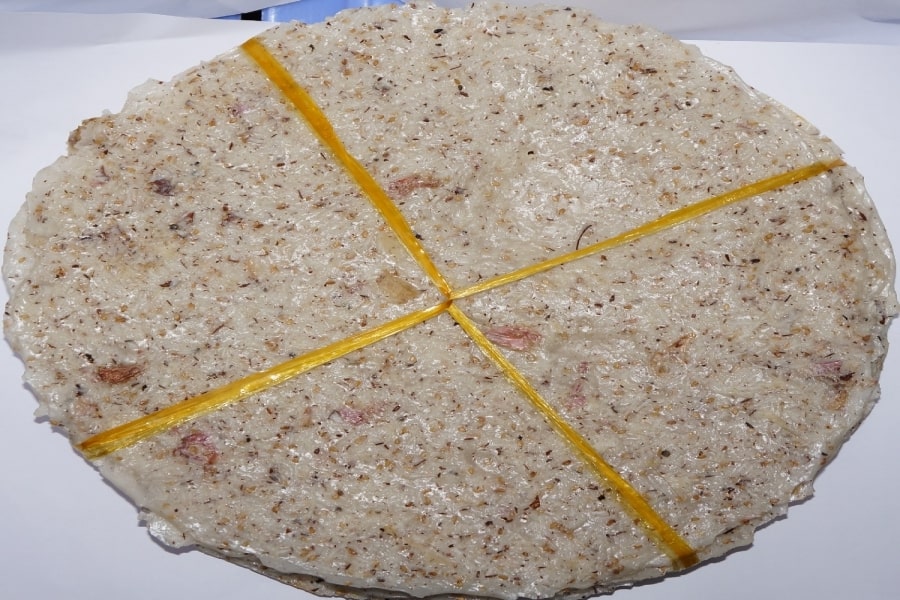 Miếng bánh tráng dừa giòn tan với lớp dừa và mè nổi bật.
